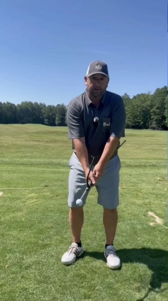 Golfer demonstrating the Swivot training system on the practice range