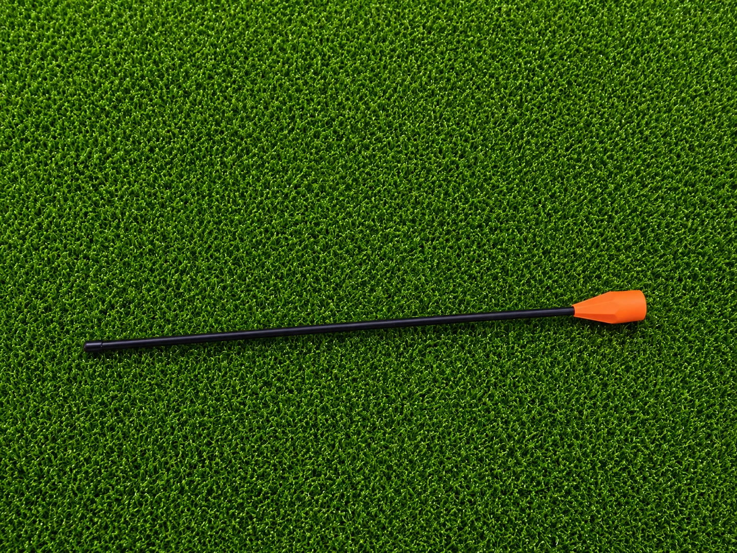 Black Swivot alignment stick with orange connector on artificial turf
